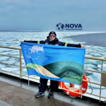 Un integrante del Ejército Argentino hace flamear la bandera de Gualeguaychú en la Antártida
